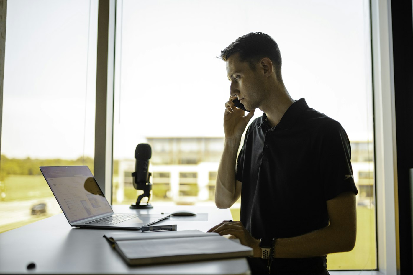 Man on the phone at his desk confirming bank details