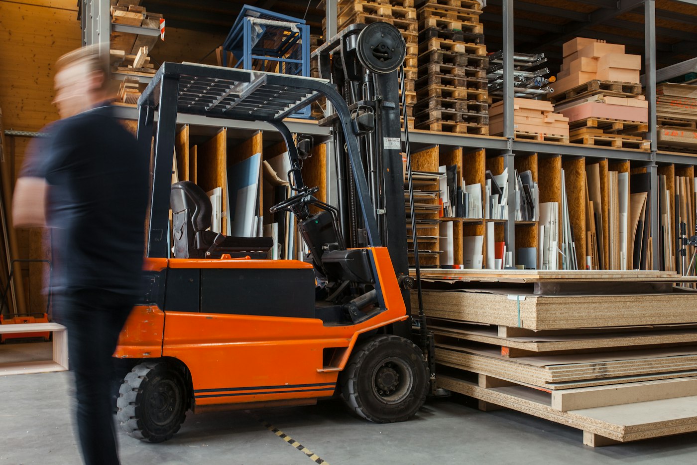 Worker driving a forklift in a large workshop